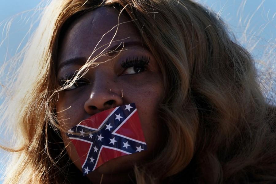 Edelia Carthan stands in silent protest with a Confederate flag sticker covering her mouth during the official opening ceremony for the Mississippi Civil Rights Museum in Jackson, Mississippi. Supporters,Trump,Donald Trump,US President Donald Trump,polarized politics