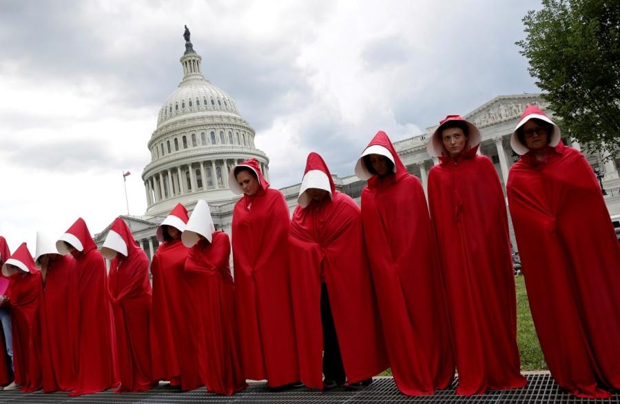 Women dressed as handmaids from the novel, film and television series "The Handmaid's Tale" demonstrate against cuts for Planned Parenthood in the Republican Senate healthcare bill at the Capitol in Washington. Supporters,Trump,Donald Trump,US President Donald Trump,polarized politics