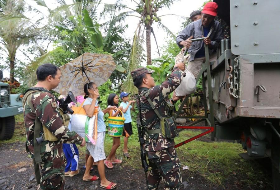 Soldiers assist residents to board a military truck as they prepare to depart to the evacuation center after Mayon volcano erupted anew, in Padang town, Albay province, Philippines January 16, 2018. Volcano in Philippines,volcano,volcano eruption,Mayon volcano spews,Mayon volcano