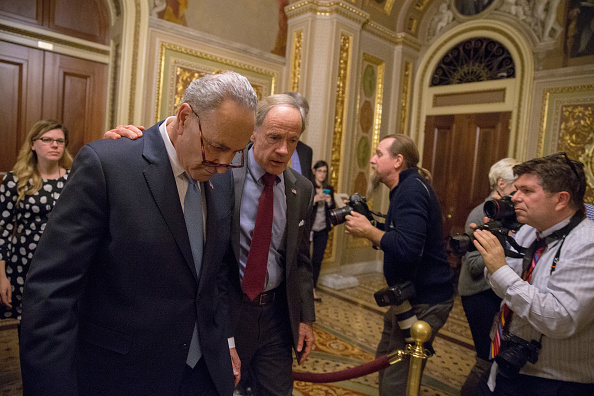 (L-R) Senate Minority Leader Chuck Schumer (D-NY) and Senator Tom Carper (D-DE) walk out of a Democratic Caucus meeting at the US Capitol on January 19, 2018 in Washington, DC. A continuing resolution to fund the government has passed the House of Representatives but faces a stiff challenge in the Senate. US Government Shutdown,US Shutdown,Senate debates,Donald Trump,US President Donald Trump,US government,US Shutdown pics,US Shutdown images,US Shutdown stills,US Shutdown pictures,US Shutdown photos