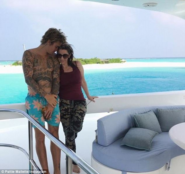 Laying at the end of a wooden dock, she positioned herself to peer into a house perched above the crystal blue water with a thatched roof. Wearing one black sandal, Pattie crosses her feet to reveal a heavy black boot on her broken foot. Justin Bieber,singer Justin Bieber,Pattie Mallette,Justin Bieber mother,justin bieber mother pattie,Justin Bieber in Maldives