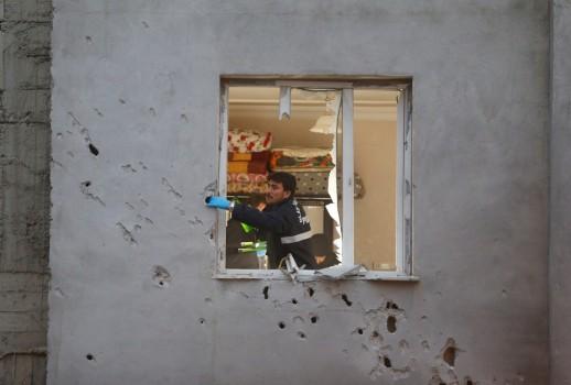 Police forensic experts examine a building which was damaged after a rocket fired from Syria landed nearby, in the border town of Kilis, Turkey January 22, 2018.