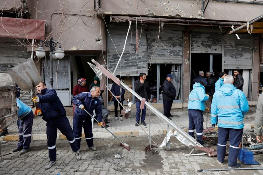 Municipality workers clean up a street in front of a building which was hit by rockets fired from Syria, in the border town of Reyhanli in Hatay province, Turkey January 22, 2018. Turkish,Turkish forces,Syria