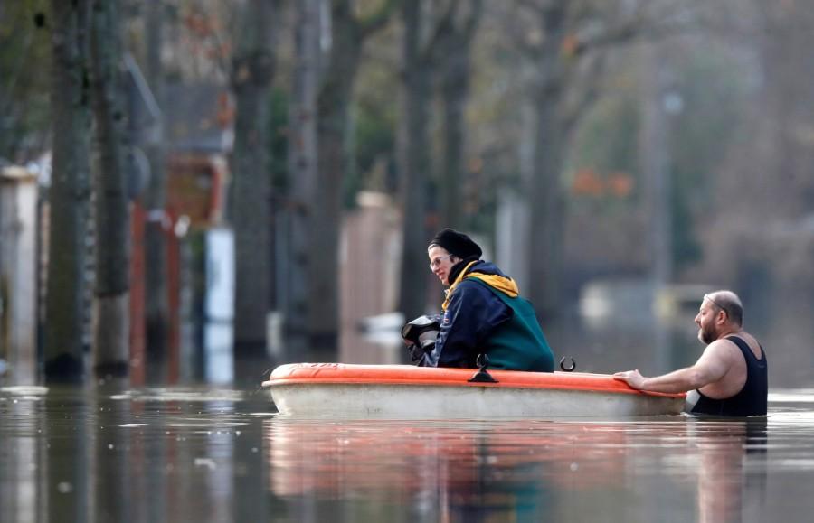 Residents use a small boat in a flooded street of Villeneuve-Saint-Georges, near Paris. Paris under water,Paris flooded,Seine bursts,Paris flooded after heavy rain,Paris heavy rain,heavy rain in Paris