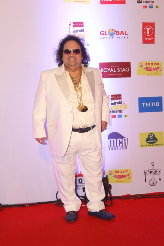 Singer Bappi Lahiri gets clicked on his arrival at the 10th Mirchi Music Awards 2018, held at Dome, NSCI in Mumbai. Singer Bappi Lahiri,Bappi Lahiri,Neetu Chandra,AR Rahman,Devi Sri Prasad,Imtiaz Ali,Arjan Bajwa,Divya Dutta,Mirchi Music Awards 2018,Mirchi Music Awards,celebs at Mirchi Music Awards