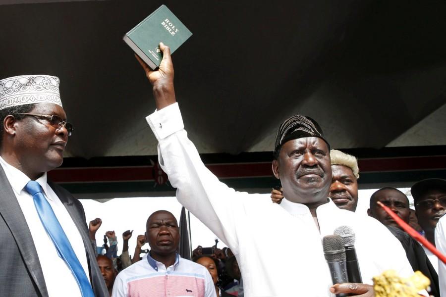 Kenyan opposition leader Raila Odinga of the National Super Alliance (NASA) holds a Bible as he takes a symbolic presidential oath of office in Nairobi, Kenya January 30, 2018. Kenyan authorities suspended television and radio stations as supporters of Odinga watched him take a symbolic presidential oath in a Nairobi park in a direct challenge to President Uhuru Kenyatta. Raila Odinga,Kenya opposition leader,President Uhuru Kenyatta,Uhuru Kenyatta