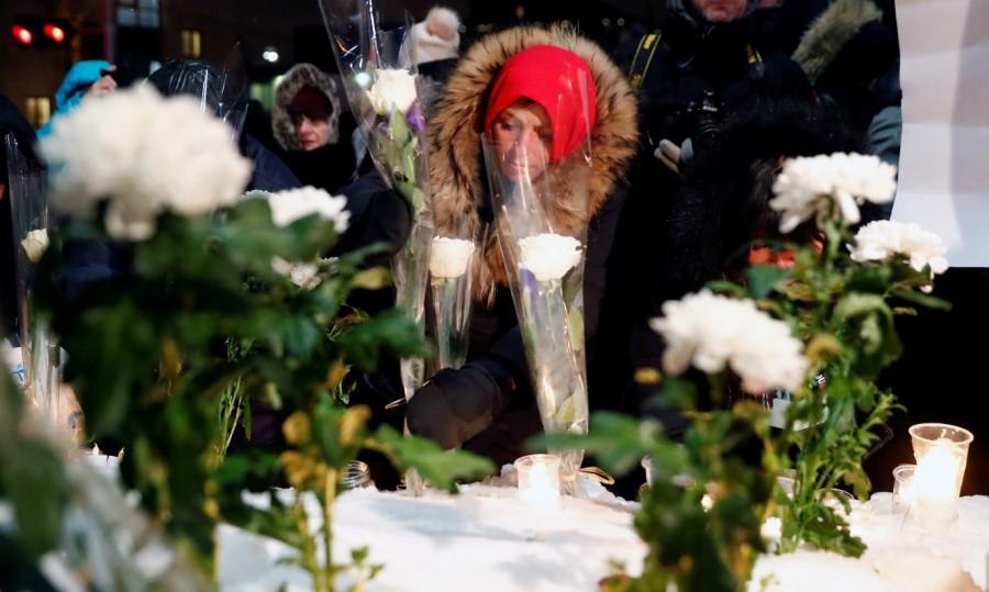 A woman leaves a flower. Quebec City mosque,Quebec mosque shooting,Justin Trudeau,Quebec City