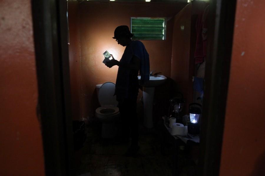 Ana Perez uses a solar lamp inside the bathroom of her home in Naguabo. Hurricane Maria,Hurricane Maria Puerto Rico,Puerto Rico struggles,Puerto Rico,Puerto Rico electricity,Puerto Rico Hurricane Maria irma,Puerto Rico food and water