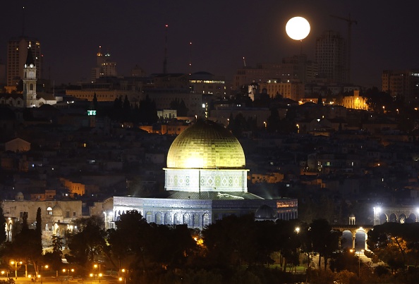The moon sets behind the city of Jerusalem early on January 31, 2018. A cosmic event not seen in 36 years -- a rare 'super blood blue moon' -- may be glimpsed today in parts of western North America, Asia. Super Blue Blood Moon,rare Super Blue Blood Moon,Eclipse 2018,Eclipse,Moon Eclipse,Super Blue Blood Moon pics,Super Blue Blood Moon images,Super Blue Blood Moon stills,Super Blue Blood Moon pictures,Super Blue Blood Moon photos,blood moon