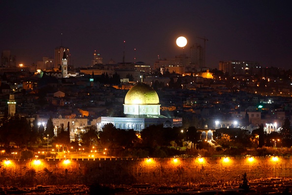 The moon sets behind the city of Jerusalem early on January 31, 2018. A cosmic event not seen in 36 years -- a rare 'super blood blue moon' -- may be glimpsed today in parts of western North America, Asia, the Middle East. Super Blue Blood Moon,rare Super Blue Blood Moon,Eclipse 2018,Eclipse,Moon Eclipse,Super Blue Blood Moon pics,Super Blue Blood Moon images,Super Blue Blood Moon stills,Super Blue Blood Moon pictures,Super Blue Blood Moon photos,blood moon