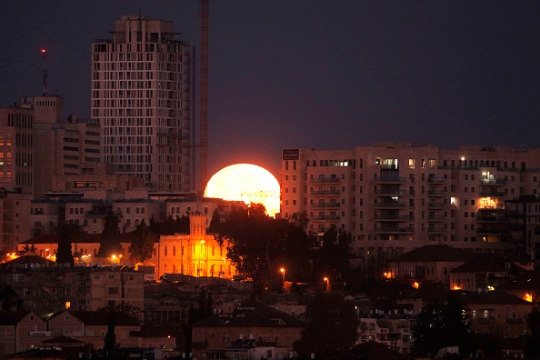 The moon sets behind the city of Jerusalem early on January 31, 2018. A cosmic event not seen in 36 years -- a rare 'super blood blue moon' -- may be glimpsed today in parts of western North America, Asia, the Middle East, Russia and Australia. Super Blue Blood Moon,rare Super Blue Blood Moon,Eclipse 2018,Eclipse,Moon Eclipse,Super Blue Blood Moon pics,Super Blue Blood Moon images,Super Blue Blood Moon stills,Super Blue Blood Moon pictures,Super Blue Blood Moon photos,blood moon