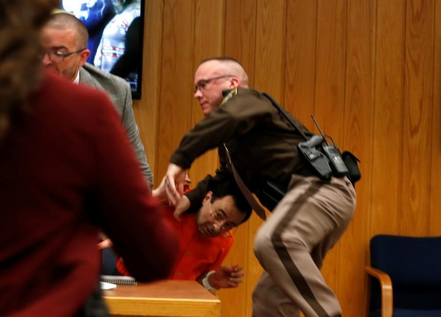 "I would ask you as part of the sentencing to grant me five minutes in a locked room with this demon," he said to the judge, gesturing toward Nassar, who has already been sentenced to up to 175 years in prison at an earlier hearing after pleading guilty to molesting young women under the guise of medical treatment. Judge Janice Cunningham told him he knew she could not do that, and chastised him after he called Nassar a son of a bitch. He asked for one minute alone instead. The judge demurred as some in the courtroom laughed uncomfortably. Larry Nassar lunges,Larry Nassar lunges father,Larry Nassar in Court
