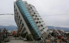 Rescue workers are seen by a damaged building after an earthquake hit Hualien, Taiwan. Rescuers combed the rubble of collapsed buildings on Wednesday, in a search for about 60 people missing after a strong earthquake killed at least six near Taiwan's popular tourist city of Hualien.