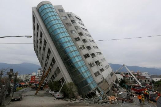 Rescue workers are seen by a damaged building after an earthquake hit Hualien, Taiwan. Rescuers combed the rubble of collapsed buildings on Wednesday, in a search for about 60 people missing after a strong earthquake killed at least six near Taiwan's popular tourist city of Hualien.