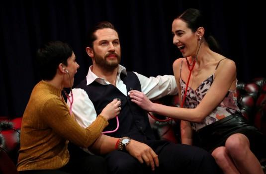 People pose next to Madame Tussauds' wax figure of British actor Tom Hardy which has a soft warm chest and a beating heart, in London, Britain.