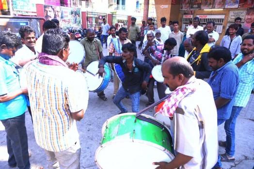 Fans dance in front of large posters and cutouts of the movie 'Gayatri'.
