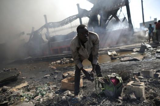 A man looks for goods amid the rubble outside of the Marche Hyppolite (Hyppolite Market), also known as Marche en Fer (Iron Market), after a fire that affected part of the market and the surrounding stands in Port-au-Prince, Haiti.