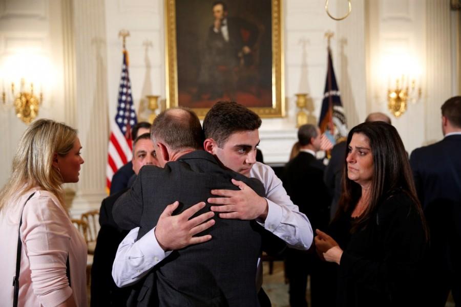 Marjory Stoneman Douglas High School shooting surviving students Jonathan Blank receives a hug from Sandy Hook parent Mark Barden, whose son Daniel was a victim of the Sandy Hook School shooting in Connecticut, after President Donald Trump held a listening session with Marjory Stoneman Douglas High School shooting survivors and students. President Donald Trump,Donald Trump,Donald Trump meets Florida school survivors,Florida school survivors,Florida school shooting survivors