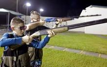 Damien Creller (L), 12, shoots during a clay target youth group shooting meeting in Sunrise, Florida.