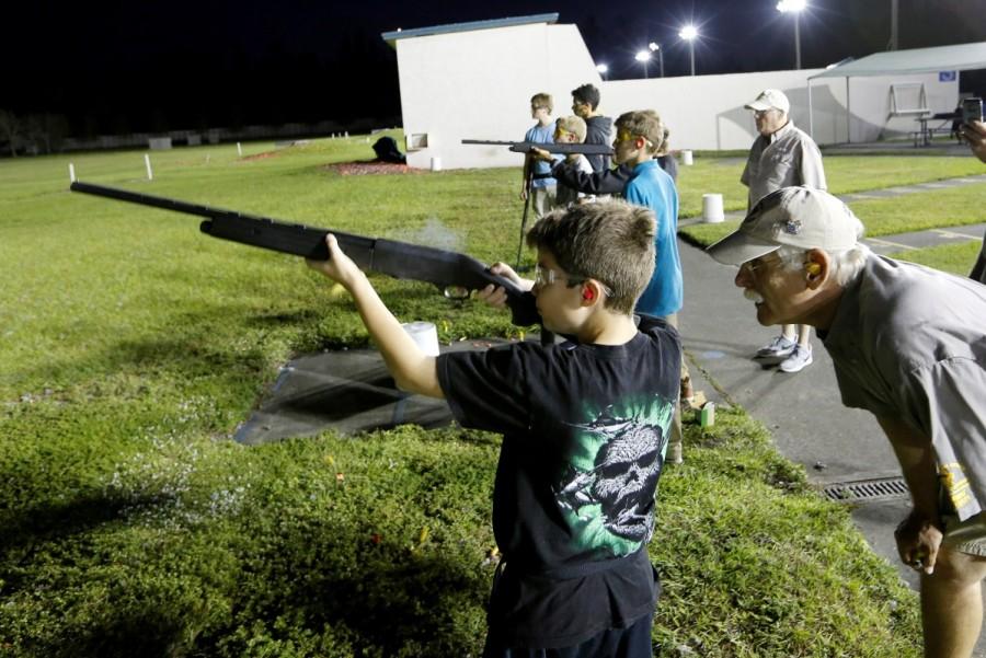 Instructor Joe Loitz (R) works with Corey George, 10, during a clay target youth shooting group meeting. Florida youth shooting club,Florida youth,youth shooting club,Marjory Stoneman Douglas High School