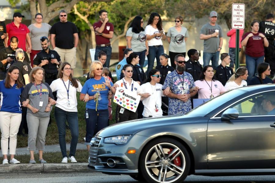 Local residents show their support as students arrive at Marjory Stoneman Douglas High School for the first time since the mass shooting in Parkland, Florida, February 28, 2018. Parkland students,Parkland students returns,mass shooting,mass school shooting,Marjory Stoneman Douglas High School