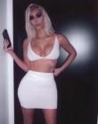 Kim Kardashian flaunts her ample cleavage and toned abs in white bra and skintight mini skirt.