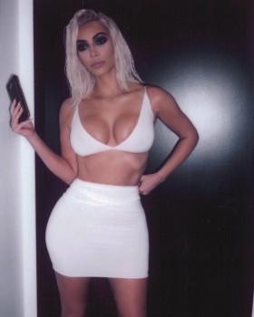 Kim Kardashian flaunts her ample cleavage and toned abs in white bra and skintight mini skirt.