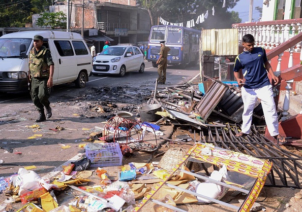 Sri Lankan police commandos patrol next to debris of from a damaged shop in the central district of Kandy on March 6, 2018, after a state of emergency was declared. Sri Lanka,Buddhist-Muslim clashes,Buddhist-Muslim fight,Buddhist-Muslim clashes in Sri Lanka,Sri Lanka nationwide state emergency,Sri Lanka emergency