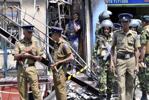 A man looks out from a burnt out home as Sri Lankan police commandos patrol on the streets of Pallekele, a suburb of Kandy, on March 6, 2018, following anti-Muslim riots that has prompted the government to declare a state of emergency.