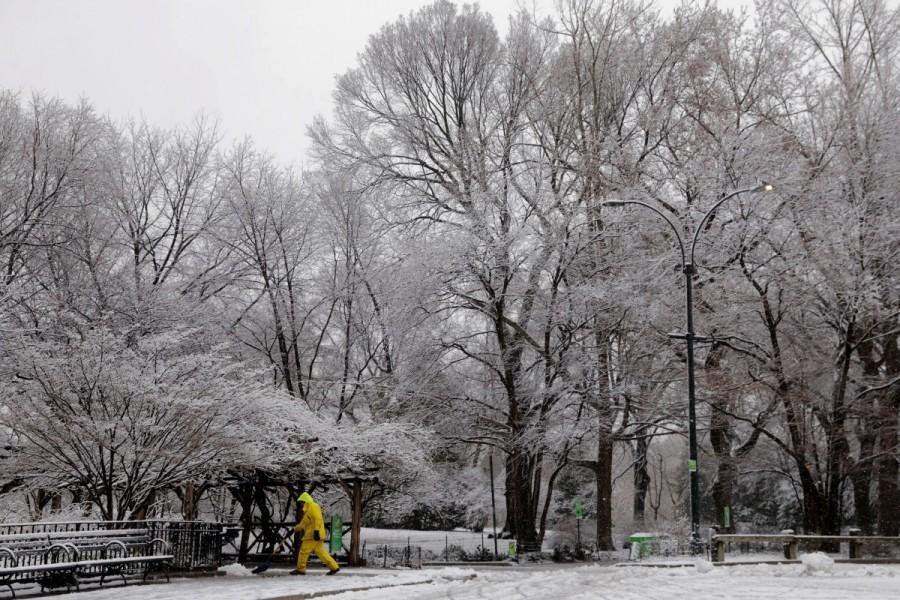 A worker clears snow from a walkway in Central Park during a snowstorm in New York. Winter storm,winter storm Northeast,Northeast,New York,New York snowfall