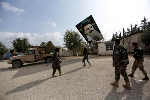 Turkish-backed Free Syrian Army fighters remove a picture of Kurdistan Workers Party (PKK) leader Abdullah Ocalan in Kafr Jana village north of Afrin, March 7.