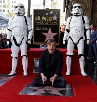 Mark Hamill poses on his star with Stormtroopers.