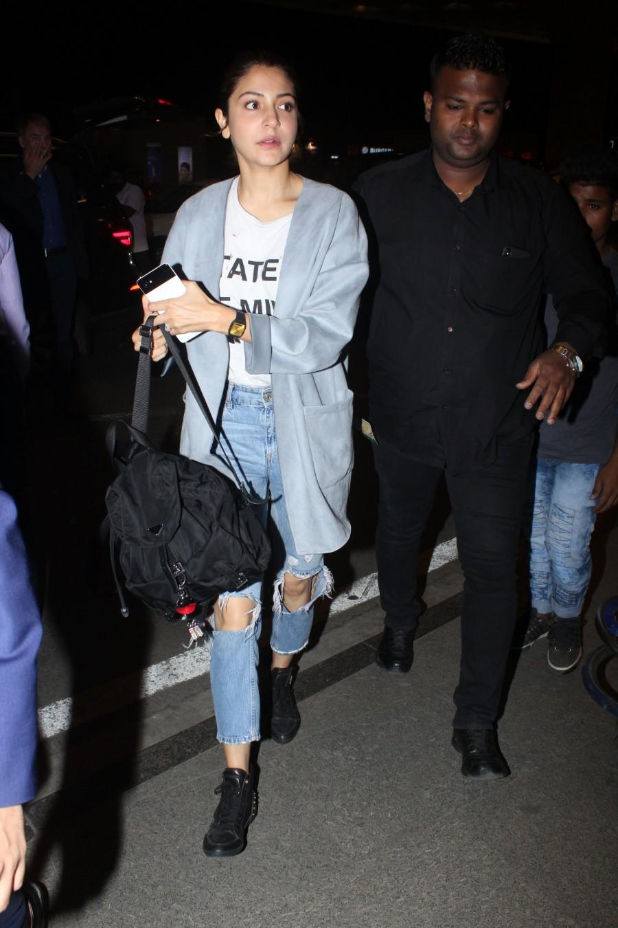 Bollywood actress Anushka Sharma owns the look in Ripped jeans at airport. Anushka Sharma,Anushka Sharma and Virat Kohli,Anushka Sharma wore Virat Kohli's t-shirt,Anushka Sharma at airport,Anushka Sharma at Mumbai airport,Virat Kohli
