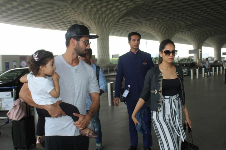 Shahid Kapoor, dressed casually in white t-shirt and black joggers holding Misha in his arms. Shahid Kapoor,Shahid Kapoor family,misha kapoor,Mira Rajput,Shahid Kapoor at airport,Shahid Kapoor family vacay,Shahid Kapoor and Mira Rajput,Shahid Kapoor pics,Shahid Kapoor images