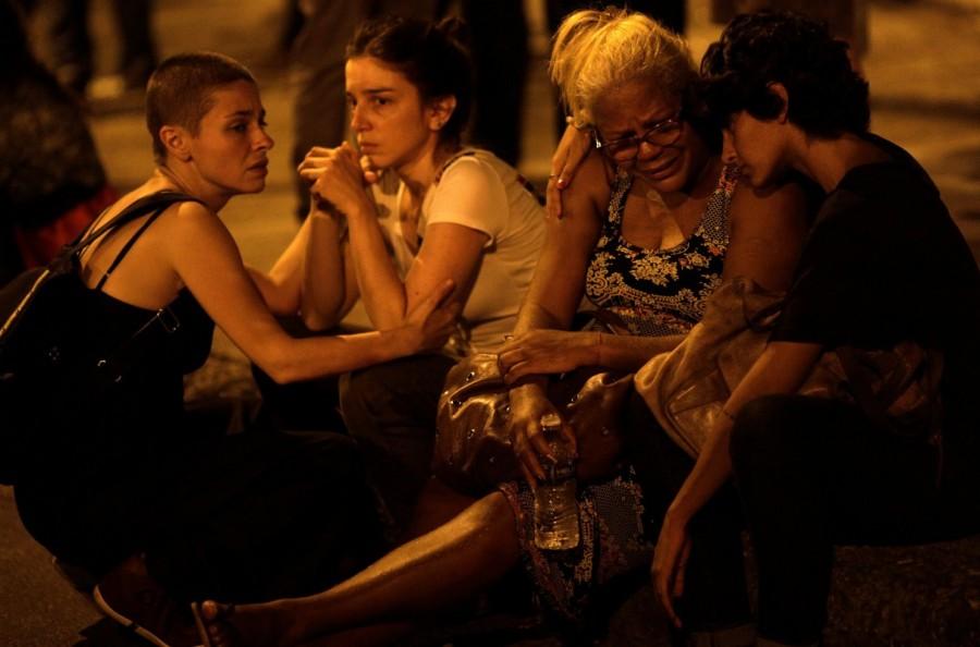 Women react next to the crime scene where Marielle Franco was shot dead in Rio de Janeiro. Brazilian activist politician,Brazilian politician,murder of Marielle,Marielle Franco,Rio de Janeiro