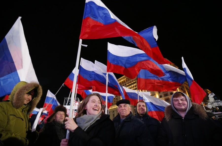 People wave Russian flags during a rally and concert marking the fourth anniversary of Russia's annexation of the Crimea region, at Manezhnaya Square in central Moscow. Vladimir Putin,Russian President Vladimir Putin,president vladimir putin,Vladimir Putin wins,Vladimir Putin re-election,Vladimir Putin pics,Vladimir Putin images