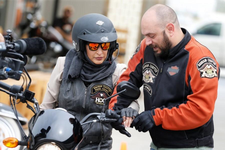 Maryam Ahmed Al-Moalem, a Saudi female bike rider, is given the basics of operating a bike by trainer Rebal Mohammed, during her lessons in advanced motorcycle training at Harley Davidson training centre in Manama, Bahrain, March 16, 2018. Maryam Ahmed Al-Moalem,Saudi woman,Saudi woman learns motorcycle,woman learns motorcycle,Bahrain