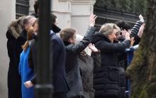 Embassy staff wave as colleagues and children board buses outside Russia's Embassy in London.