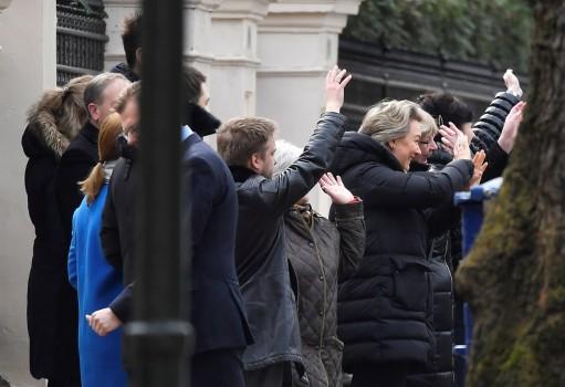 Embassy staff wave as colleagues and children board buses outside Russia's Embassy in London.