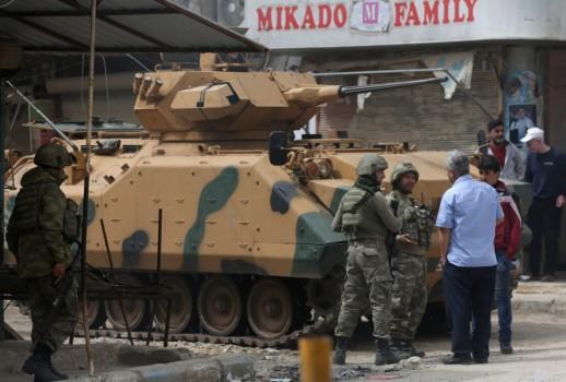 People speak with Turkish soldiers in the center of Afrin, Syria March 24, 2018.
