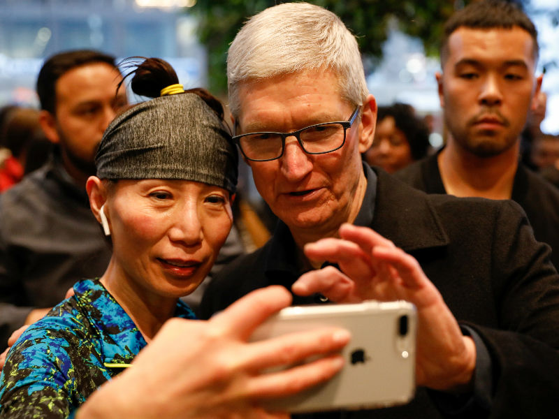 Tim Cook, Chief Executive Officer of Apple Inc., takes a selfie with a customer and her iPhone as he visits the Apple Store in Chicago, Illinois, U.S., March 27, 2018. Apple,Apple CEO Tim Cook,Apple educational event,Apple Pencil,Cassey Williams,Cathleen Richardson,chicago,Froggipedia App,Greg Joswiak,IOS,ipad,iPad 9.7,iPhone,Lane Technical College Prep High School,Susan Prescott,Tim Cook