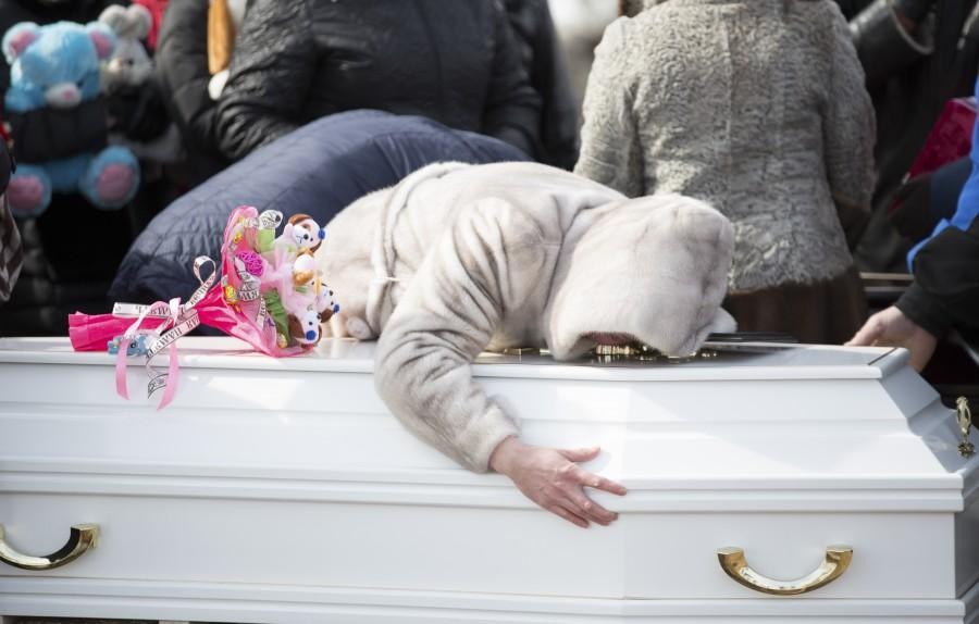 A woman reacts during a funeral of a victim of a shopping mall fire at a cemetery in Kemerovo, Russia March 28, 2018. Mourning after Russia mall fire,Russia mall fire,russia mall fire death,russia mall fire photo,Siberian shopping mall