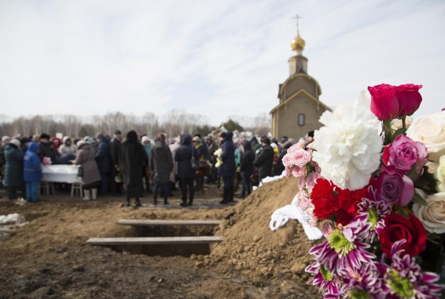People attend a funeral of a victim of a shopping mall fire at a cemetery in Kemerovo, Russia March 28, 2018. Mourning after Russia mall fire,Russia mall fire,russia mall fire death,russia mall fire photo,Siberian shopping mall