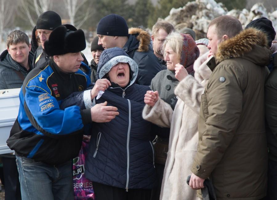 People react during a funeral of a victim of a shopping mall fire at a cemetery in Kemerovo, Russia March 28, 2018. Mourning after Russia mall fire,Russia mall fire,russia mall fire death,russia mall fire photo,Siberian shopping mall