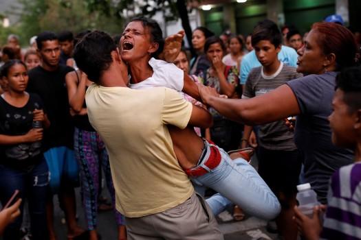 Relatives of inmates held at the General Command of the Carabobo Police react as they wait outside the prison, where a fire occurred in the cells area, according to local media, in Valencia, Venezuela March 28, 2018.