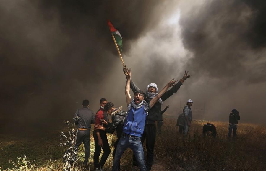Palestinian demonstrators shout during clashes with Israeli troops at a protest demanding the right to return to their homeland, at the Israel-Gaza border east of Gaza City April 6, 2018. Gaza-Israel border,Israeli troops,Palestinian protesters,Gaza border