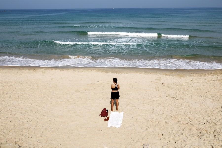 A beachgoer stands still as a two-minute siren marking the annual Israeli Holocaust Remembrance Day is heard in Tel Aviv, Israel, April 12, 2018. Holocaust Remembrance Day,Remembrance Day,Holocaust Remembrance Day pics,Holocaust Remembrance Day images,Israel stands silent