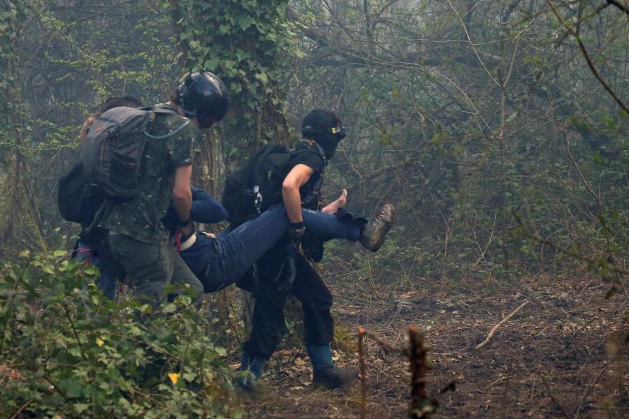 An injured protester is carried through the forest during clashes with French gendarmes who continue an evacuation operation in the zoned ZAD (Deferred Development Zone) at Notre-Dame-des-Landes, near Nantes, France, April 12, 2018. French police,eco-activists,western France,French police swoop