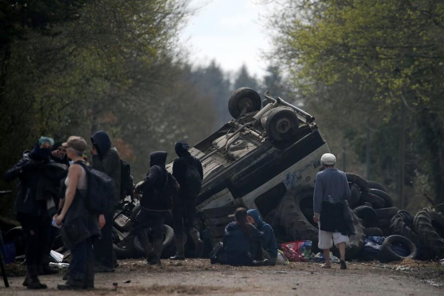 Protesters gather near debris that barricades a road as French gendarmes continue an evacuation operation in the zoned ZAD (Deferred Development Zone) at Notre-Dame-des-Landes, near Nantes, France, April 12, 2018. French police,eco-activists,western France,French police swoop