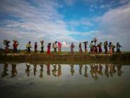 The photography staff of Reuters has won the Pulitzer Prize in Feature Photography for their coverage of the Rohingya migrant crisis between Myanmar and Bangladesh. Rohingya refugees are reflected in rain water along an embankment next to paddy fields after fleeing from Myanmar into Palang Khali, near Cox's Bazar, Bangladesh November 2, 2017.